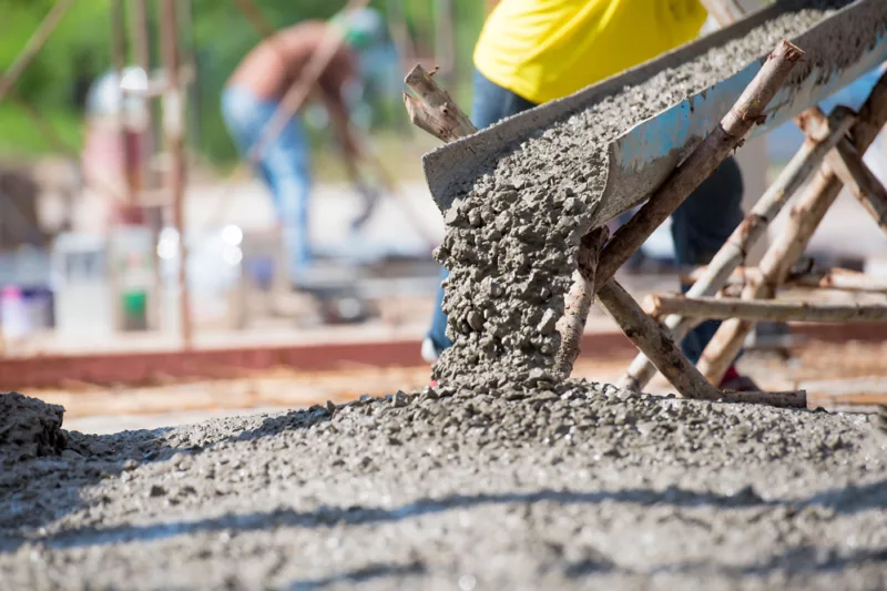 Beton fließt durch eine Rinne auf einer Baustelle